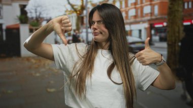 Canlı bir şehir caddesinde gündüz vakti şehir ortamında karışık duygular ifade eden genç bir kadın..