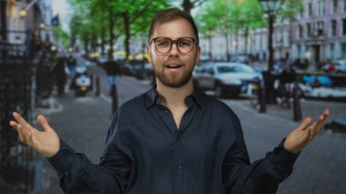 Bulanık trafik ve kanal binaları arasında adam iki eliyle bir şehir caddesinde bardakları ayarlar; kafa karıştırıcı sorgulama.