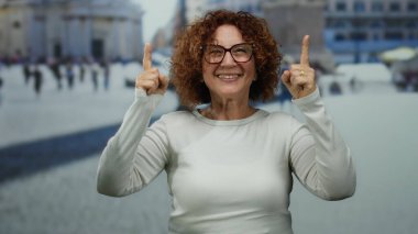 Beyaz gömlekli bir kadın Vatikan 'ı işaret ediyor. İkonik St. Peter' ın arka planıyla, neşeli açık hava deneyimini yakalıyor.