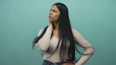 Boyun ağrısı, uzun siyah saç ve çatık kaşlı ifade için el pençe divan duran bir kadın..