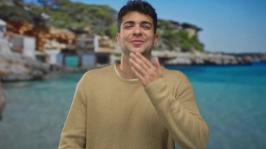 Adam elini kaldırır ve kameraya doğru hafifçe vurur. Genç İspanyol adamın, ışıl ışıl gülümsemeden önce dudaklarına öpücük kondurmasıyla..