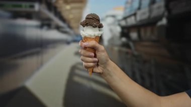 Gemi seyahatinde elinde dondurma külahıyla gezen, deniz kenarında gösteri yapan, sıcak ve sakin bir ortamda, lezzetli bir tatlı eşliğinde seyahat etmenin zevkini yaşayan bir adam..