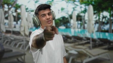 Kulaklık takan genç adam kameraya bakıyor.