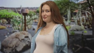 Orman açıklıklarında ağaçların arasında parmak ucuyla işaret eden genç beyaz kadın, tetikte.