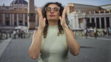 İspanyol genç kadın dua ederken el ele tutuşur kubbenin altında antik binanın dışında huzur içinde durur..