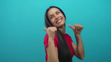 Kırmızı tişörtlü İspanyol kadın geriye doğru neşeli bir gülümsemeyle parlak mavi duvarlı izole edilmiş arka planda..