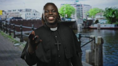 Erkek rahip, papaz tasması ve haç takan, inanç neşe topluluğuna sıcak bir hoş geldin der..