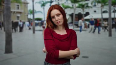 Dışarıda kolları çapraz duran bir kadın.