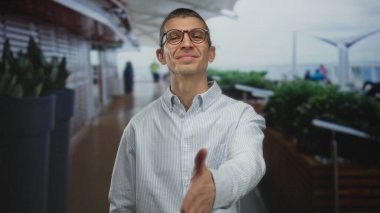 Arka planda bulanık yürüme yolu olan, günlük gömlekli bir adam arkadaşlığı iletiyor ve gündüz ortamına hoş geldin diyor..