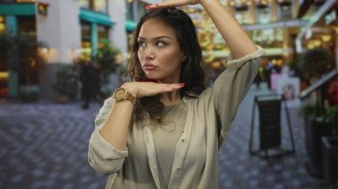 İspanyol kadın hareketli caddede elleri ile çerçeve jest yapar; yaratıcılık hayal gücü perspektifi vizyon.