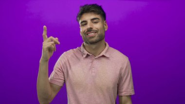 Sakallı genç İspanyol adam gülümsüyor ve parmağını yukarı kaldırıyor..