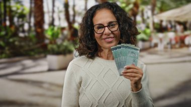 Malezya sirkesi banknotlarını elinde tutan kadın şehir merkezinde bir sokakta para ve finansman gösterisi yapıyor..