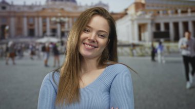 Roma 'da güneş ışığı altında Vatikan binasının önündeki kameraya çevrilmiş gülümseyen genç kadın:.