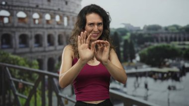 Genç İspanyol kadın, Roma Kolezyum Binası 'nda güneş ışığı altında el ele tutuşuyor..