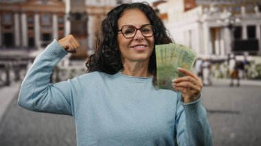 St. Peter Meydanı, Vatikan 'da elinde Arjantin banknotları tutan ve kolunu güçlü bir şekilde esneten orta yaşlı bir kadın..