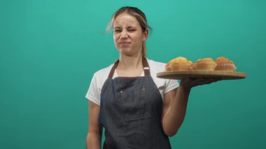 Kadın sarışın fırıncı kot önlük giyiyordu. Kek tepsisi tutuyordu. Suratları asıktı ve el sallıyordu..