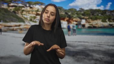 Stüdyo plaj setinde elleri olan kadın, kapalı gözler ve odaklanmış ifade; konsantrasyon iletişimi.