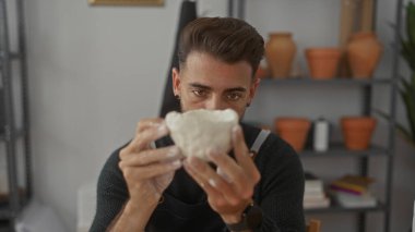 İnsan stüdyoda el yapımı, çıplak elle yapılmış beyaz bir klozeti döner ve inceler..