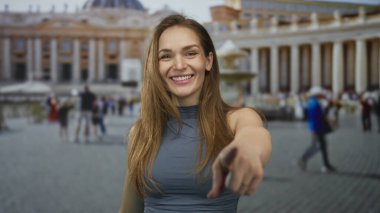 Kadın, Vatikan St. Peter Meydanı 'ndaki fıskiyeli sütun binasına parmağıyla işaret ediyor..