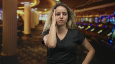 İnşa ederken alnına slot makinesinin yanında dokunan kadın, yumruk yumruğa ve çökmüş duruş; hüsran yenilgisi.