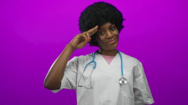 Stüdyoda parlak mor duvara karşı steteskop gülümseyen ve selam veren kadın doktor..