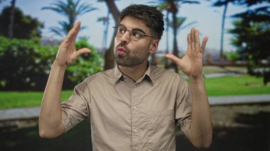 Ormanda yüzün yakınındaki elleri parlak güneş ışığı altında berraklaşan hayali sahneyi çerçeveleyen adam; yaratıcı görüş tefekkür.