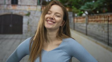 Kadın el ele tutuşup, sokak ortasında demir çitle, bina cephesi ve kapı önünde el ele tutuşuyor..