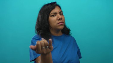 Mavi gömlekli, çatık kaşlı bir kadın stüdyoya doğrudan bakarak kamerayı işaret ediyor; öfke suçlaması.