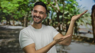 İspanyol adam şehir sokaklarında elini uzatıyor neşeli bir ifadeyle bir şeyler gösteriyor..