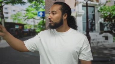 Beyaz t-shirt ve sakal giyen bir adam, yön tarifi belirleme.