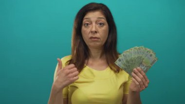 Kolombiya 'nın 1000 peso' luk banknotunu destekleyen bir kadın, deniz mavisi atölyesinde başparmağıyla işaret ediyor..