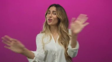 Mor arka planda, parlak stüdyoda iki çıplak el sallayan bir kadın. Keyif eğlencesi coşkusu..