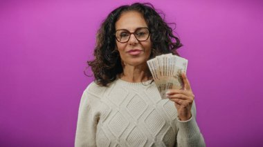 Rusya 'nın ruble banknotlarını elinde tutan kadın canlı mor bir arkaplan ile finans ve para birimi temalarını özgüvenli bir ifadeyle sergiliyor..