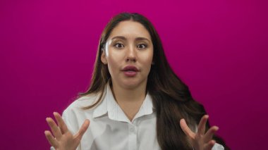 Beyaz gömlekli kadın yumruklarını sıkar ve dinamik bir kutlamada mor stüdyoda ağzını açar. Zafer sevinci..