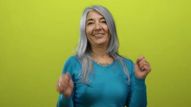 Gri saçlı, neşeli, sarı bir arka plana gülümseyen, neşeli, izole edilmiş bir ortamda pozitif duygularını ifade eden, mutluluk ve iyimserliği öneren son sınıf öğrencisi kadın..