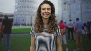 Genç İspanyol kadın, kalabalık meydanda uzanan kulede parlak güneş ışığı altında avuçlarını kaldırıyor; keyif yolculuğu.