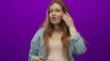 Bir stüdyo seansında uzun saçlarını mor bir arka plana değdirirken tatmin olmamış görünüyor..