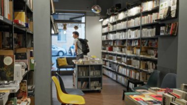 Kitapçıda raflar ve sığ bokeh 'te oluşturulan kitap yığınları ve bir dükkânda odaklanan yumuşak odaklı kitapçıların içi; arkaplan fotokopi alanı sakin.