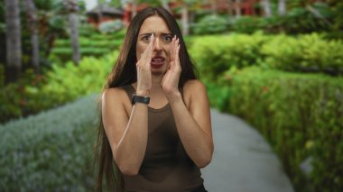 Ağzı açık, ağzı açık, gözleri açık, orman yolunda el ele tutuşan bir kadın endişeye kapılıyor..