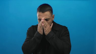 Genç İspanyol adam sıkıca burnunu sıkar ve canlı mavi stüdyoda gözlerini kapatır; koku rahatsız edici tiksinti.