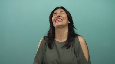 Stüdyoda gözleri kapalı ve omuzları açık bir kadın gülüyor; mutluluk rahatlığı sakin.