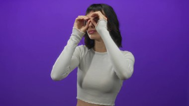 Mor stüdyoda el hareketleriyle çerçevelenmiş odaklanmış genç kadın gözleri..