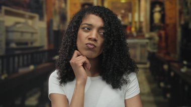 Eli çenesinde olan Afrikalı Amerikalı bir kadın kilise sığınağında ahşap bir sıranın üzerinde oturuyordu..