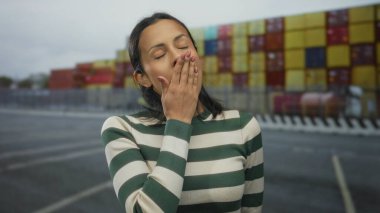 İspanyol kadın deniz kıyısında renkli konteynırlarla düşünceli görünüyor. Deniz manzarası ve yansıma hissi var..