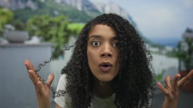 Afrika kökenli Amerikalı bir kadın ormanda el ele tutuşup geniş gözlü ve ağzı açık bir şekilde dağlara bakıyor..