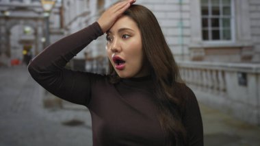 Açık ağızlı genç İspanyol kadın, loş ışıklı şehir caddesinde el ele tutuşuyor..