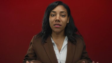 Kadın kırmızı stüdyoda ileri hareketi durdurmak için ciddi bir ifadeyle el ele tutuşuyor..