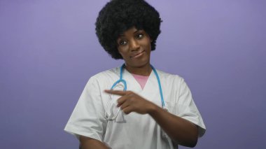Steteskop kullanan kadın doktor mor stüdyoda parmaklarını her iki tarafa işaret ediyor; belirsizlik seçenekleri araştırması.