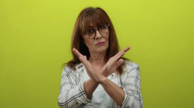 Çapraz kollu bir jest yapan kadın, direniş ve kararlılığı somutlaştıran, protesto ve sınır belirleme temaları öne sürüyor..