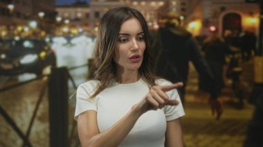 Gece şehir caddesinde parmakla parmakla işaret eden kadın, kararlılık.